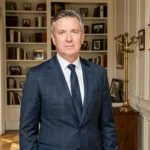 Portrait d'un homme distingué dans un appartement parisien élégant, évoquant la vie privée et le parcours personnel de Richard Caillat